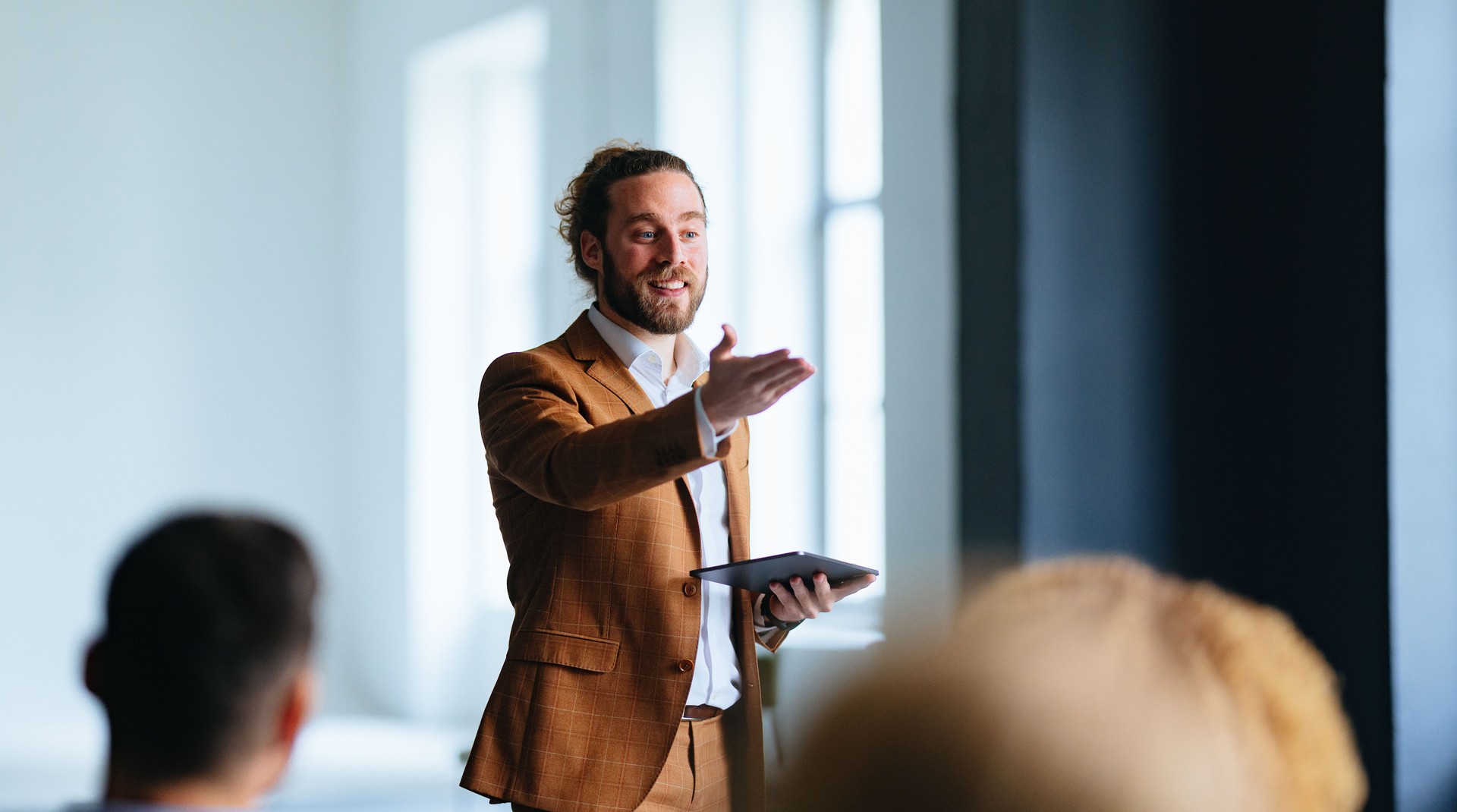 Smiling Business Man Talking And Pointing To Audience During A Q And A Session