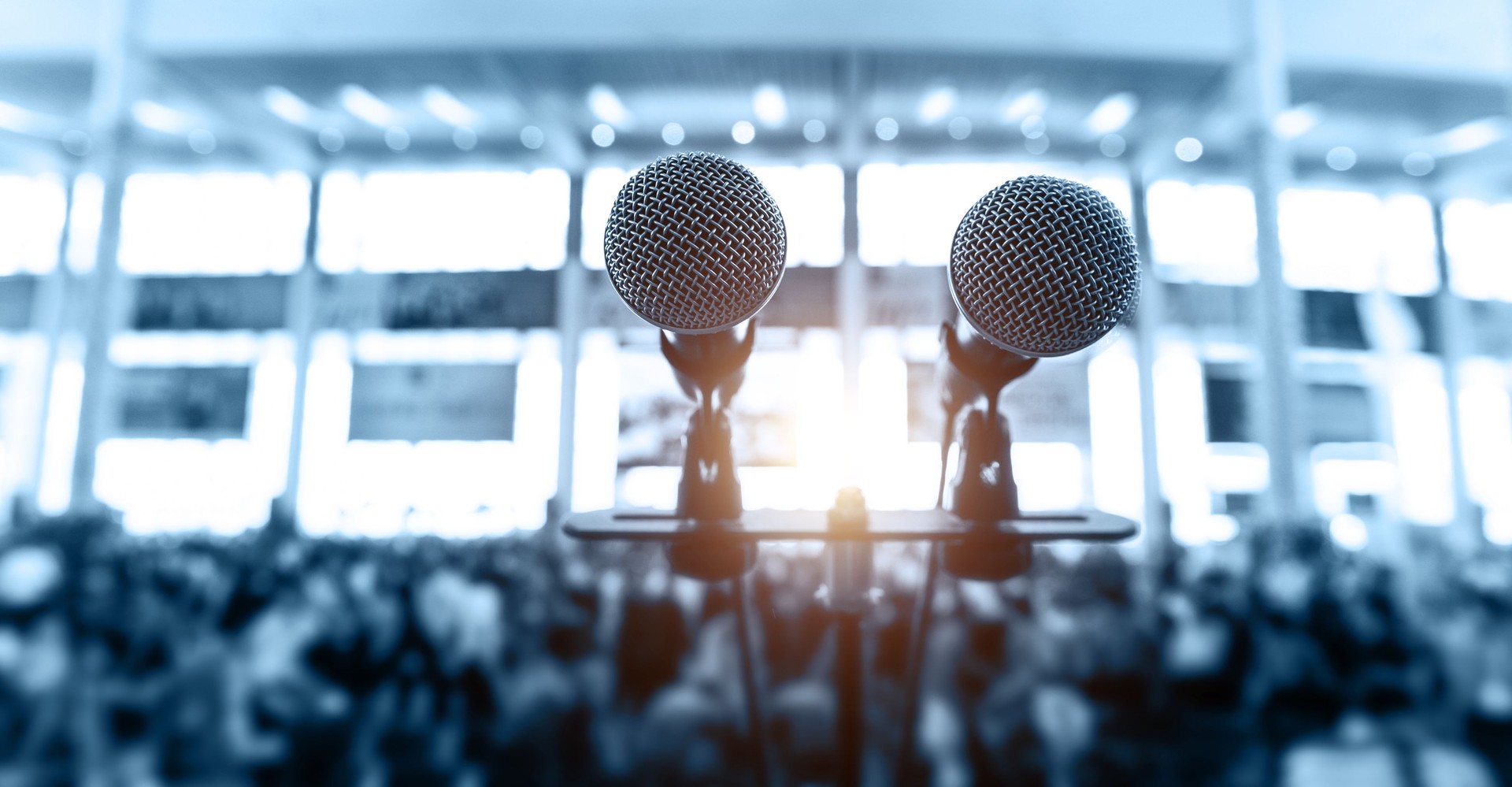 Closeup microphone in auditorium with blurred people in the background