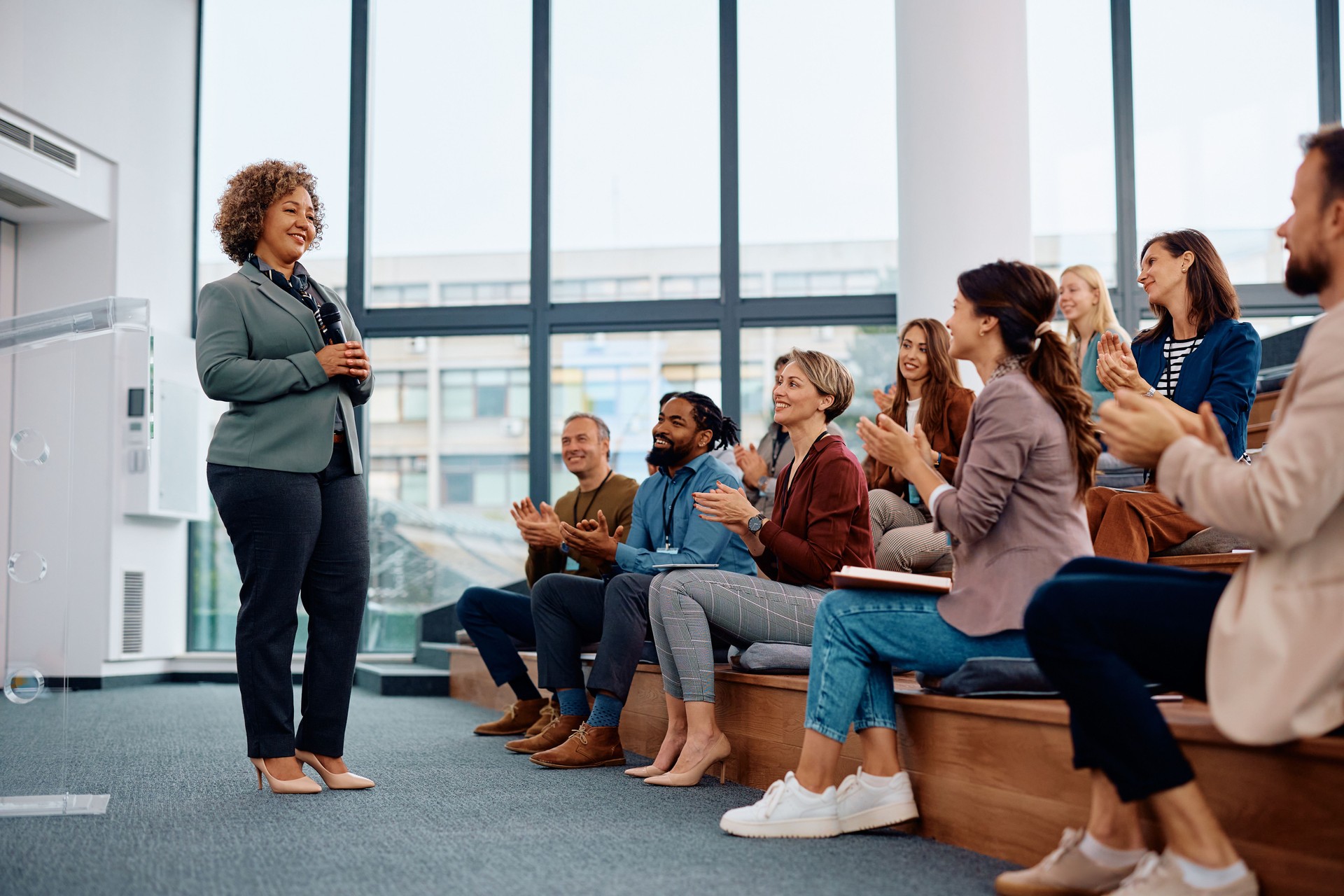 Mature businesswoman getting an applause after successful speech during a seminar in conference hall.