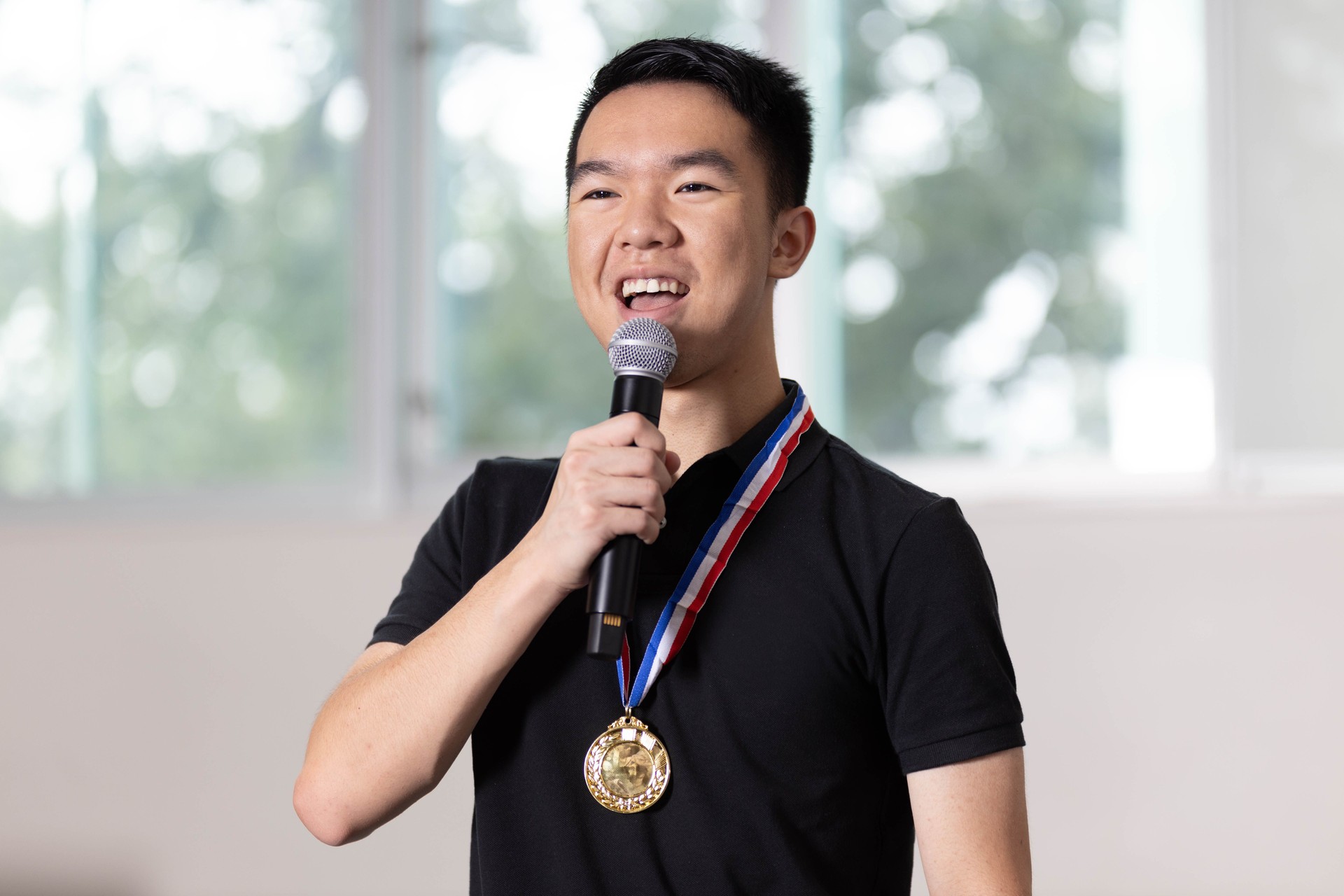 Teen boy giving a speech after winning a gold medal in a competition